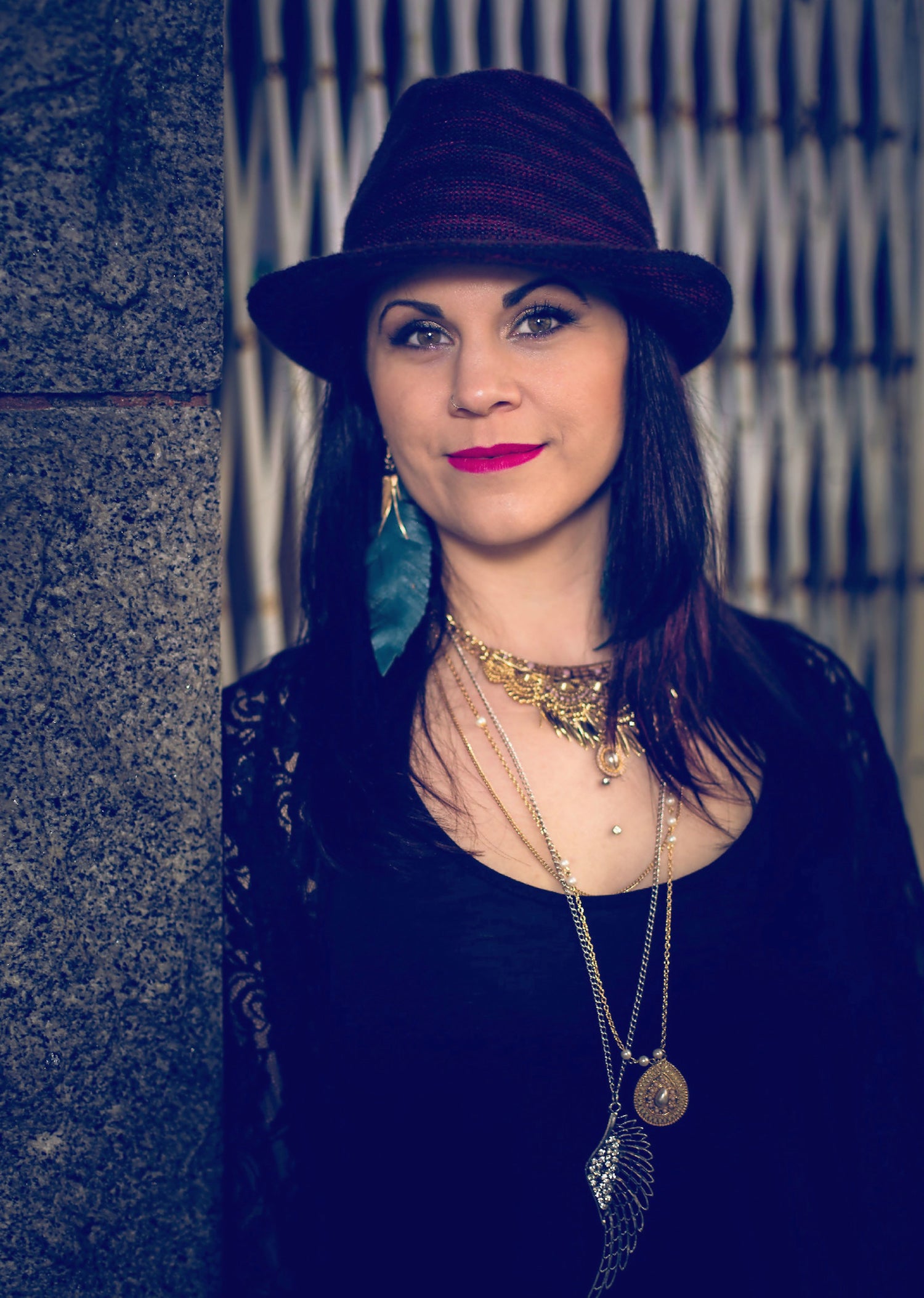 Melody Lovejoy wearing a fedora purple earrings and boho fashion